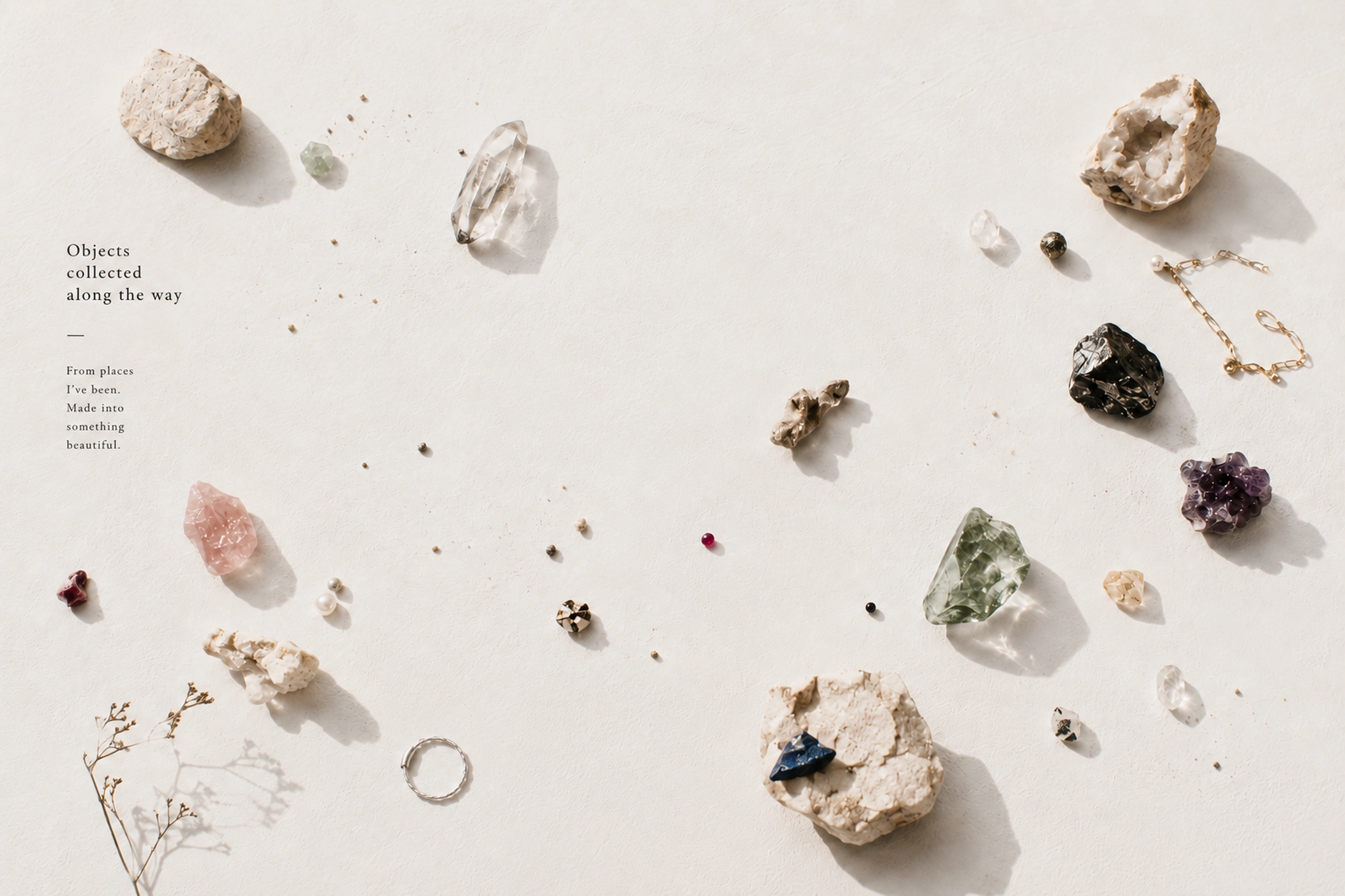 Collected jewelry, stones, and objects arranged on linen